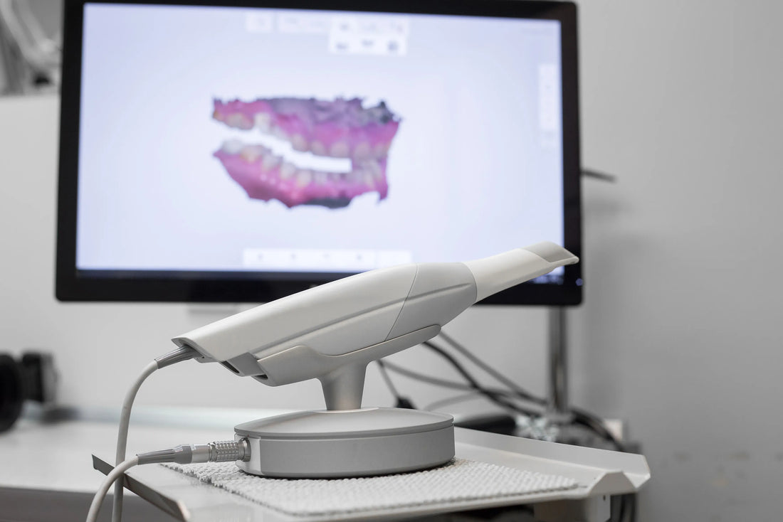 CAD/CAM dental scanner with a digital scan of teeth displayed on a computer screen, demonstrating modern dental technology used for accurate restorations